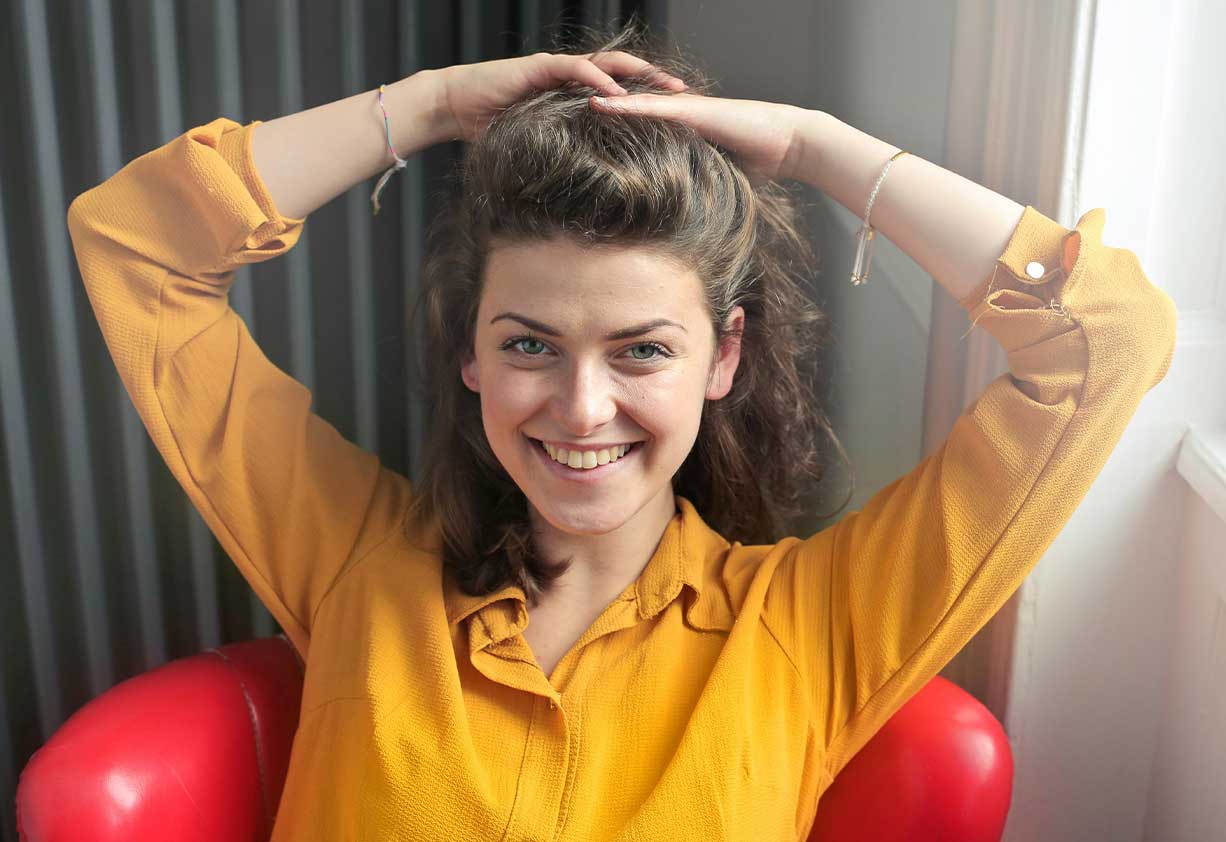 women in yellow shirt smiling at camera wondering what LASIK would be like